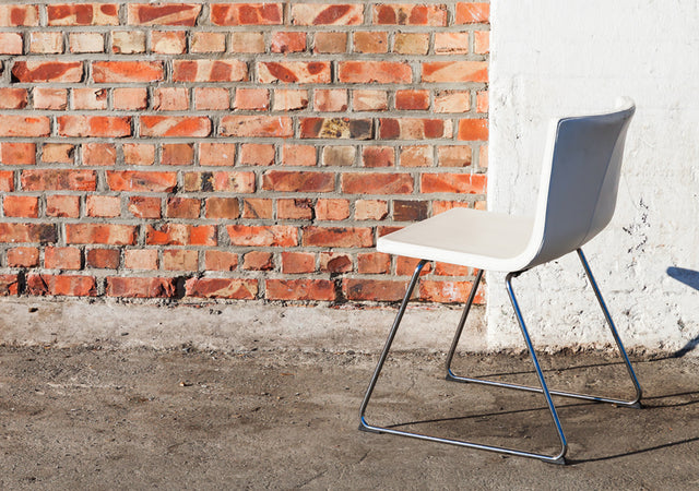 MTL Gebrauchtmöbel moderner Stuhl vor Steinmauer